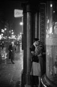 GB. England. London. A rainy night in Oxford Street where a young couple seek a tender moment in a doorway. 1960.