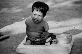 CAMBODIA. Phnom Penh. Pheak, twelve years old, is from the eastern province of Prey Veng. He was brought to the city by his parents to beg. Armless and legless, he is fed and cared for by his brother. 1995