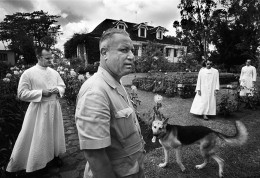 A rare moment when the constituent symbols of colonialism come together in a frame. On a French sugar plantation the owner, with his dog, guide visiting priests around the garden of his mansion. MAURITIUS. 1966